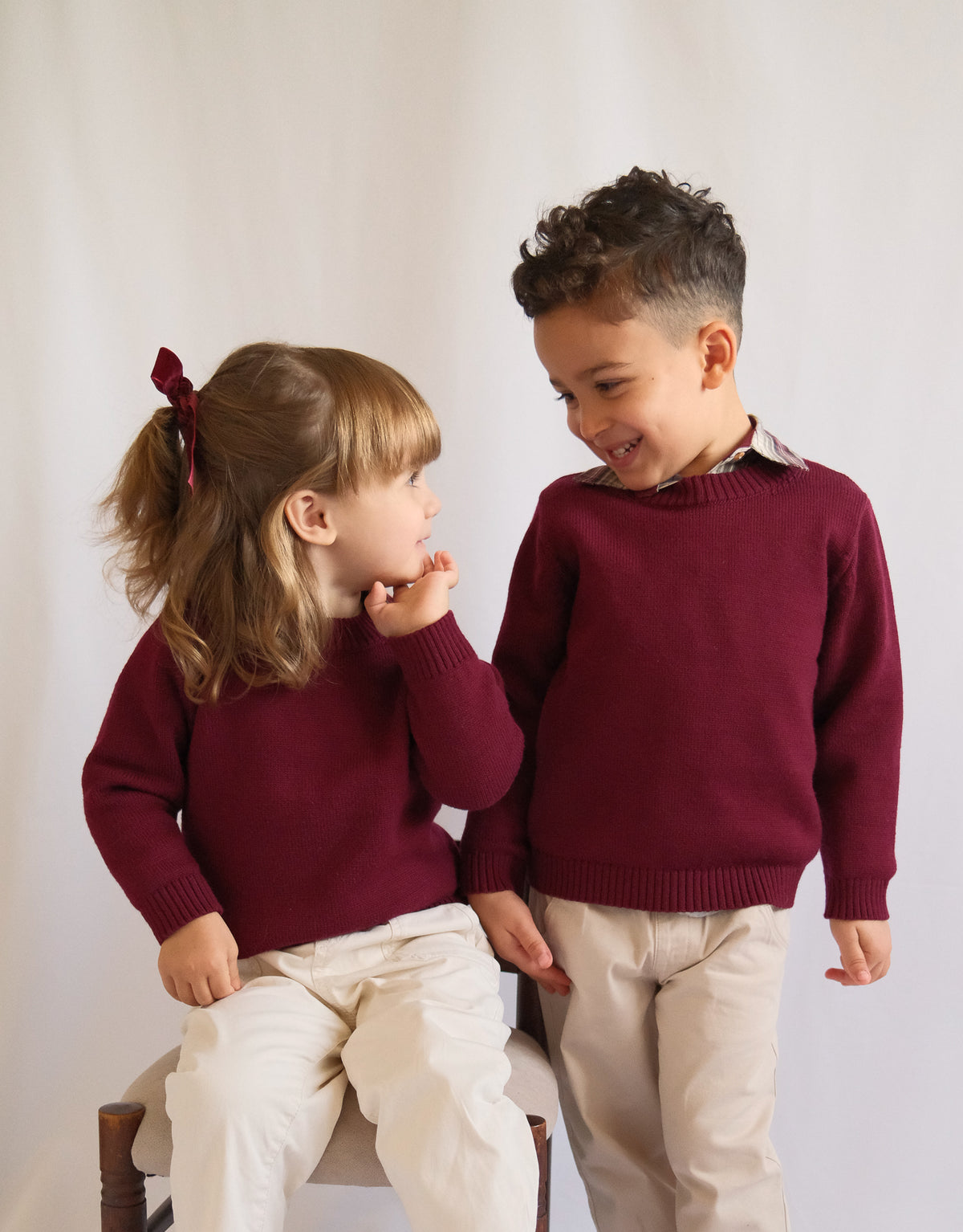 TANSY merlot red merino wool sweater for children in an editorial photograph